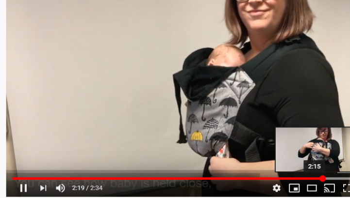Mum standing sideways with her newborn baby in an integra carrier